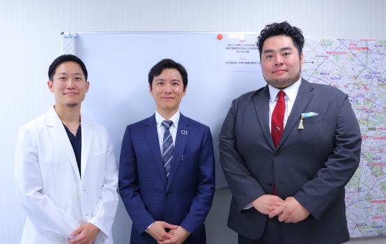 春山記念病院の方と並んで記念撮影をしている深堀純也医師