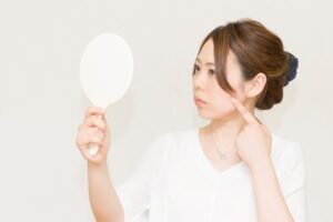 鏡を見て頬を触る女性01