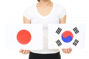 日本と韓国の国旗を比較する女性