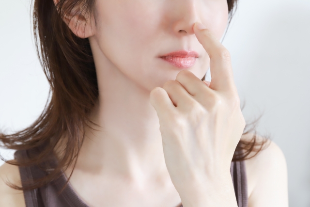 鼻に指を当てる女性