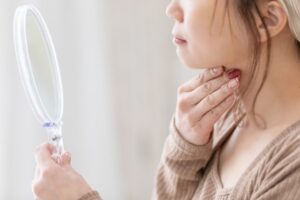 顎下を触る女性