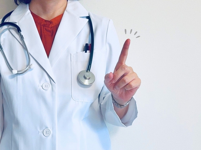 白衣を着て指差しをする医師
