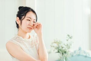 目をこする女性