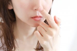 鼻を触る女性
