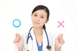 ○と×のプレートを持つ医師