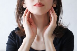 顎下を触る女性
