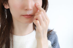 目の下を触る女性