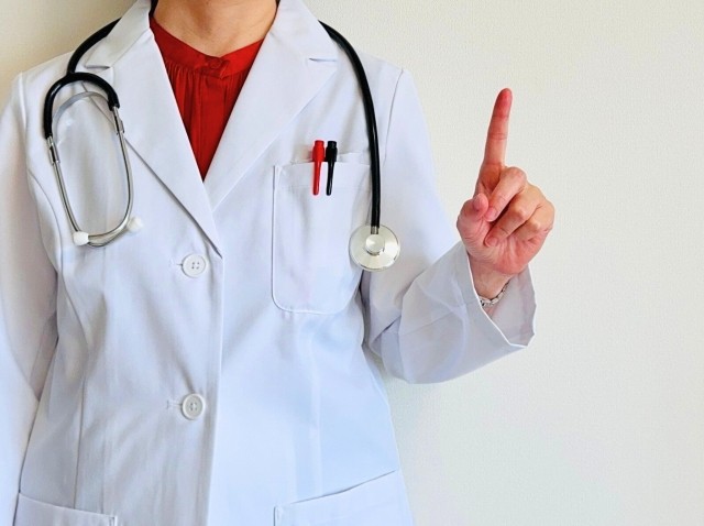 白衣を着て指差しをする医師