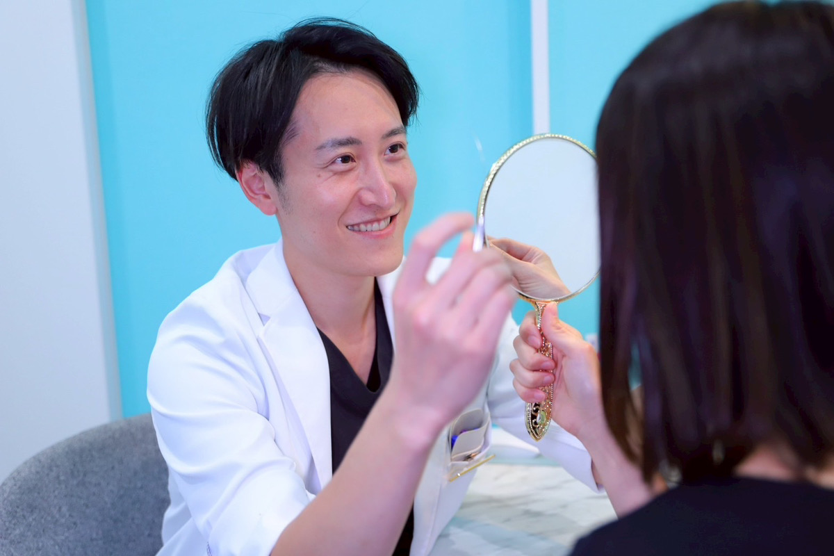 髙田医師が患者の顔に鏡を向ける様子