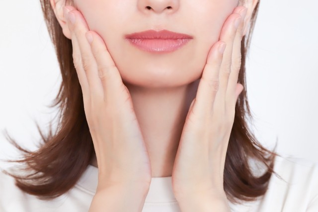 顔に手を添える女性