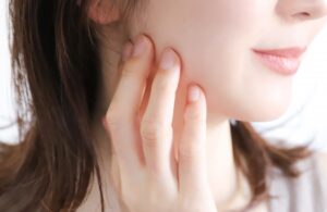 頬を触る女性