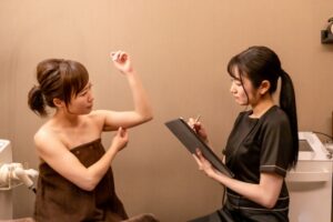 医師に二の腕を診せる女性