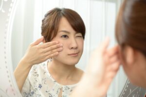 目の下を触る女性