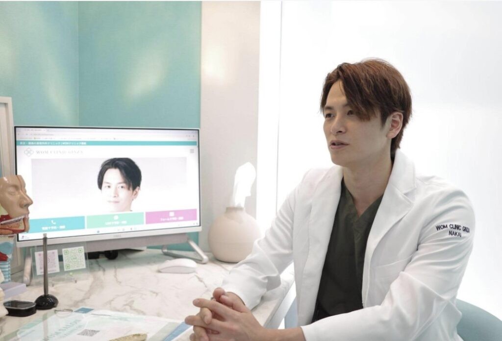 白衣を着た男性医師がデスクで説明する様子