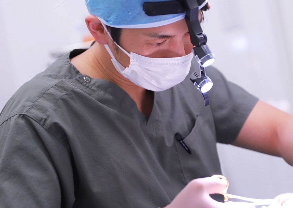 手術器具を使い処置をする男性医師