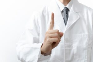 人差し指を立てる医師