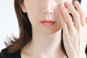 目の下を触る女性