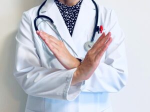 バツ印を作る医師