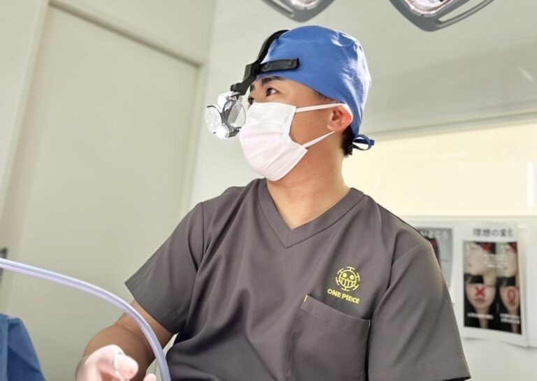 手術着を着て拡大鏡をつけた男性医師