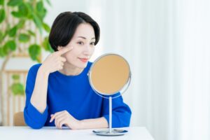 鏡で顔を確認する女性
