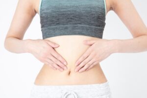 両手でお腹を押さえる女性
