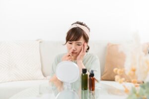 鏡で鼻を気にする女性