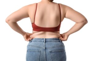 背中の肉をつまむ女性の後ろ姿