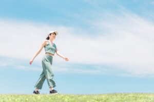 青空の下で歩く女性