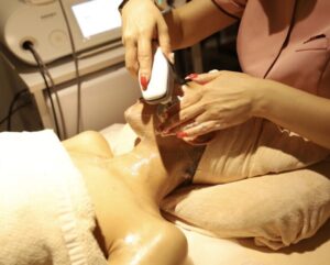 エステティシャンが顧客の顔に施術