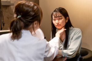 医師が患者の顔を診察する様子