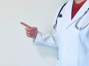 白衣の医師が右方向を指差す