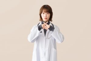 白衣の女性が腕を交差させるポーズ