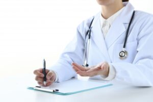 白衣を着て問診票に記入する医師