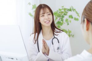 白衣を着て座る女性医師と向かい合う患者