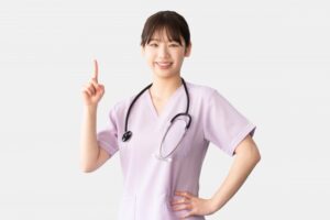 笑顔で指をさす女性医療従事者