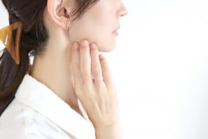 女性が顎に手を当てる