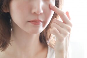目元を指で触れている女性