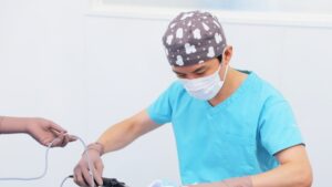 手術着を着て医療器具を扱う医師