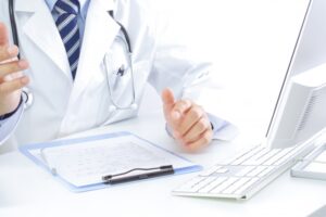 医師が机で患者のデータを見る