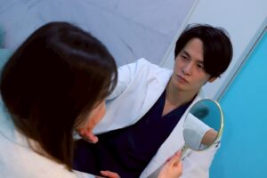 白衣の男性が鏡を女性に見せる