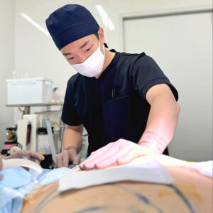 手術中に患者の腹部を処置する医師