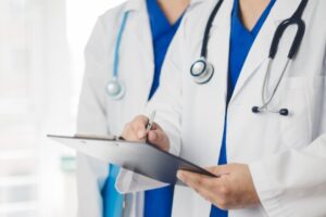 白衣の医師二人がカルテを記入