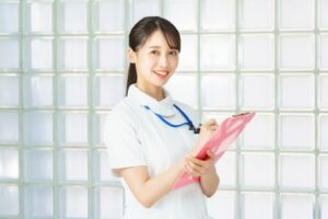 白衣を着てバインダーを持つ女性