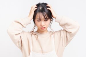 頭を抱えて困っている女性