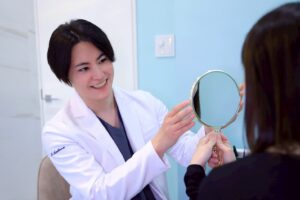 白衣の男性が女性に鏡を渡す様子