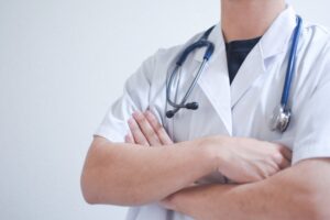 腕組みする白衣の医者と聴診器