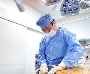 手術衣を着て処置を行う医師