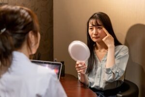 女性が鏡を見ながら美容カウンセリングを受ける様子