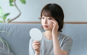 鏡で目元を確認する女性