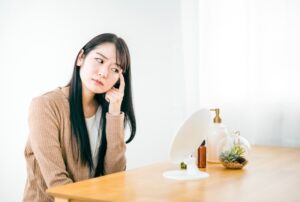 鏡の前で顔を触る女性